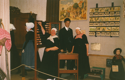 N 8123 - twee vrouwen in tipmutsdracht; links Gerrie Rekers en rechts Fenna de Boer in het 'schooltje' in de oudheidkamer
