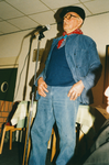 N 8147 - man, in spijkerbroek, pet op, rode zakdoek om de hals, achter een microfoon; Gart de Zwaan
