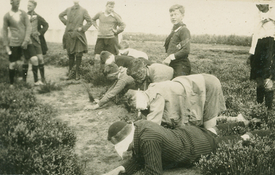 9978 - Groep mannen met lap voor de ogen, liggend op de gornd
