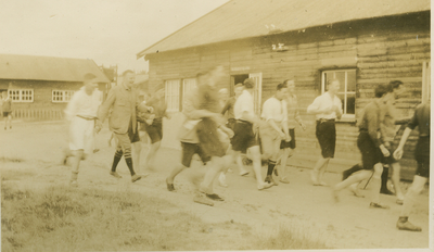 9995 - groep jongemannen hardlopend langs een barak
