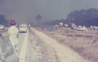 2251 Grote brand 't Harde. Mensen kijken, naast hun stilstaande auto's, naar de dikke rookwolk over de snelweg A28.