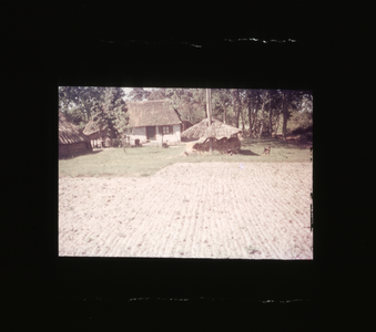  Wit boerderijtje met op de voorgrond een hooiberg en akkerland