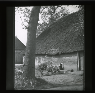  Zijgevel van een rietgedekte schuur met melkbus