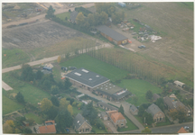 13941 - Luchtfoto met onderaan de Harderwijkerweg met aan weerzijden woonhuizen, grasvelden, geboomte, industriële ...