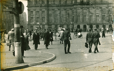 16703 - Drie duitse militairen lopen met het geweer op de schouder door Amsterdam. Op de achtergrond het Paleis op de Dam.