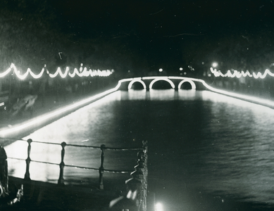 16957 - Nachtfoto van een verlichte gracht met verlichte guirlandes in verband met vijtigjarig jubileum van koningin ...