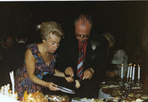 7064 - Mevrouw Van de Wel en de heer Vellekoop staan voor een buffet. Bij besluit van 7 juni 1974 werd de Zilveren Pauw ...