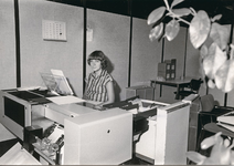 8476 - Mevrouw Henny Laanstra-van Harskamp aan het werk achter haar boekhoudmachine op de afdeling 'Boekhouding'