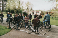 8714 - Fietsers op landgoed Veldwijk zijn bijeen in verband met een fietsbomenroute. De man met zijn rug naar de camera ...