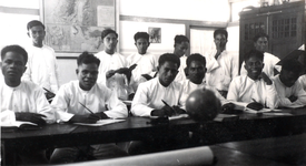 12 Tweede klasse studenten in hun leslokaal in de 'School tot Opleiding voor Inlandsche Leraars' (STOVIL) te Soë, ...