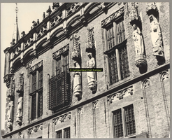 F001365 Beelden en laat-gotische ijzeren kooi aan de gevel van het Oude Raadhuis aan de Oudestraat, v.l.n.r. Karel de ...