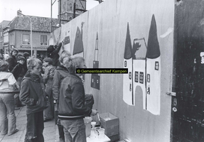 F005727 Beschildering van een omheining rond Buitenkade 2 en 4 door schoolleerlingen.