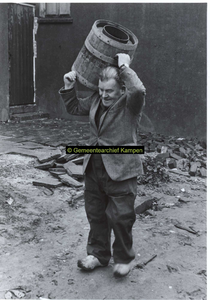 F006996 De laatste ton wordt gelicht uit het buiten toilet aan de Reijersdijk door ambtenaar Jan Schreurs.