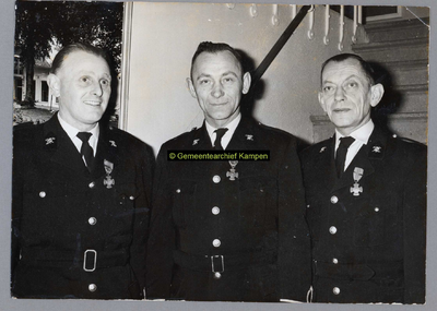 F003019 De brandweerlieden C.J. Selles, B. Hanekamp, en J. Bos tijdens de viering van hun 12 jarig jubileum.