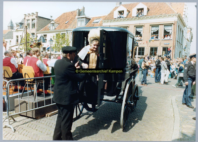 F005016 Een vrouw in Kamper klederdracht stapt uit de koets aan de Koornmarkt tijdens de feestelijkheden in de stad ter ...