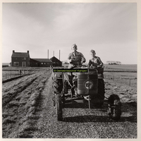 F001089 Boer Van Zuthem met zoon op tractor; op de achtergrond zijn boerderij erf 138.