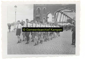 F003155-1 Marcherende leden van de S.S. de W.A. en Jeugdstorm over de IJsselbrug.