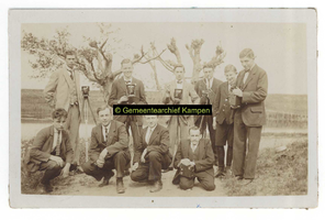 F004625-2 Groepsfoto van 10 mannen met een fotocamera, de man links onder is Jan Teune.