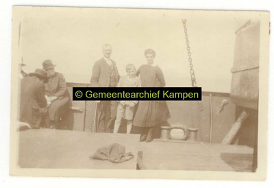 F004602-2 Onbekend gezin (vader, moeder en kind) met een drietal medepassagiers aan boord van een schip.