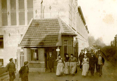 F009561 Het personeel van Berk (B.K.) verlaat de fabriek bij de uitgang met portiershok aan de Noordweg.