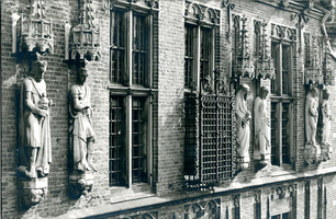 F004229 Beelden en laat-gotische ijzeren kooi aan de gevel van het Oude Raadhuis aan de Oudestraat, v.l.n.r. Karel de ...
