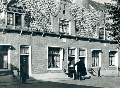 F004257 Bewoners op de binnenplaats van de Proveniershuisjes uit 1695 van de Verenigde Gasthuizen.