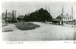 F013068 Reproduktie van een prentbriefkaart Tusschen de Haven , de huidige Havenweg die gelegen is tussen de ...