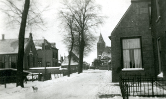 F009898 IJsselmuiden, de Dorpsweg in de winter van 1950, links de Chr. school, in het midden de toren van de N.H. kerk. ...