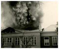 F001007 De rook en vlammen slaan uit het dak van de Koornmarktskazerne, waarin ten tijde van de brand de Tweede ...