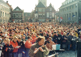 F013272 Kinderzang op de Nieuwe Markt ter ere van Koninginnendag.