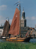 F013213 Twee houten zeilschepen, platbodems, op de IJssel, waarvan één een botter. Met op de achtergrond, markant, de ...
