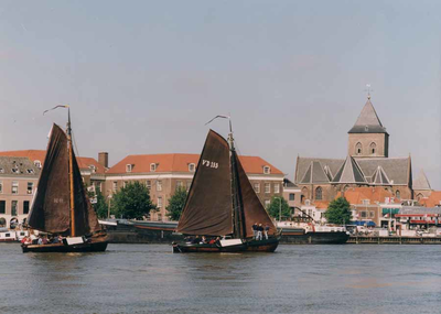 F013214 Twee houten zeilschepen op de IJssel, met op de achtergrond de Van Heutszkazerne en rechts daarvan de Buitenkerk.