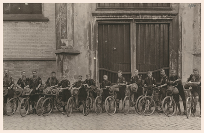 F002730 Groep padvinders op de fiets voor de ingang van de Bovenkerk aan de Oudestraatzijde.