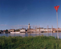 F013245 Afgemeerde zeilboten van de bruine vloot aan de IJsselkade bij Kampen. Met links de oude stadsbrug. In het ...