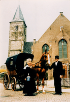 F013315 Echtpaar in IJsselmuider klederdracht met paard getrokken koets voor de Hervormde kerk in de Dorpsweg.