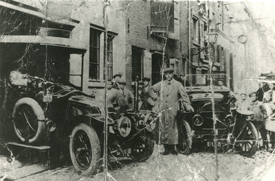 F005706 Achterzijde van de garage van J.W. Wolters (Oudestraat 40) aan de Hofstraat, de kleine man links, naast de ...