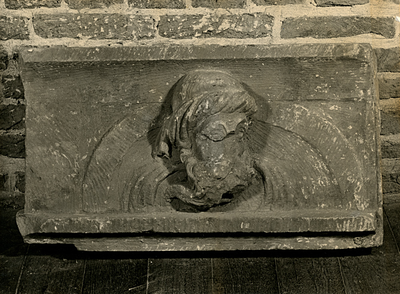 F003324 Hardstenen 16e eeuwse gevelsteen voorstellende een mannenhoofd voor een boog.