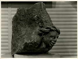 F003346 Turfstenen 14e eeuws kapiteeltje van een hoofd met gevlochten haar, afkomstig van een onbekend gebouw.