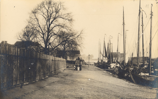F000287 De Havenweg. Rechts ligt de Kamper vissersvloot afgemeerd in de Buitenhaven, langs de weg links het houten hek ...