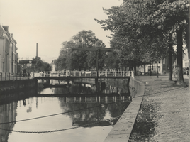 F000383 Tussen de Burgwal (rechts) en de Vloeddijk (links) ligt de Meeuwenbrug. Op de achtergrond staat een gashouder ...