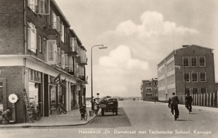 F000589 De Dr. Damstraat in de Hanzewijk, links winkels met daarboven woonflats, rechts de Ambachtschool (Lagere ...