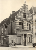 F000263 Hoekhuis met 17e eeuwse trapgevel, aan weerszijde boven de ramen van de begane grond twee gevelstenen van ...