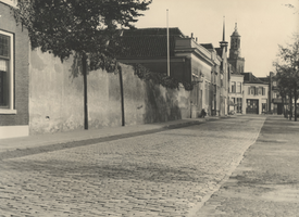 F000425 De Burgwal, links de muur die de tuin van de R.K. pastorie van de straat afsluit, in het verlengde van de ...