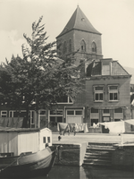 F000430 De Burgwal, op de voorgrond een woonark in de stadsgracht de Burgel, op de achtergrond de toren van de Buitenkerk.