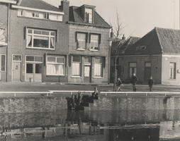 F000433 Spelende kinderen op een trap in de kademuur van de stadsgracht, achter de drie kinderen op de kade een rijtje ...