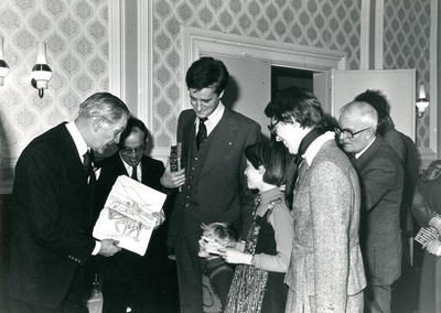 F000658 Burgemeester Sybren van Tuinen (1e van links) neemt een tekening in ontvangst ter ere van zijn afscheid, 3e van ...