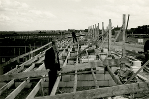 F011494 Rond 30 aug 1966 bracht men de dakgordingen van de in aanbouw zijnde flatwoningen aan in de Erfgenamenstraat te ...