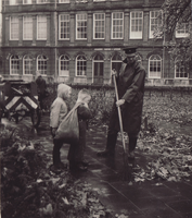 F000738-1 Twee kinderen helpen de stratenveger die aan het werk is in het Engelenbergplantsoen (1961).