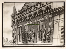 F001354 Beelden en laat-gotische ijzeren kooi aan de gevel van het Oude Raadhuis aan de Oudestraat, v.l.n.r. Karel de ...