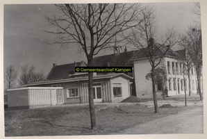 F001022 Nederlands Hervormde Kerk met meesters- en kosterswoning aan de Heultjesweg op het Kampereiland. Voor het ...